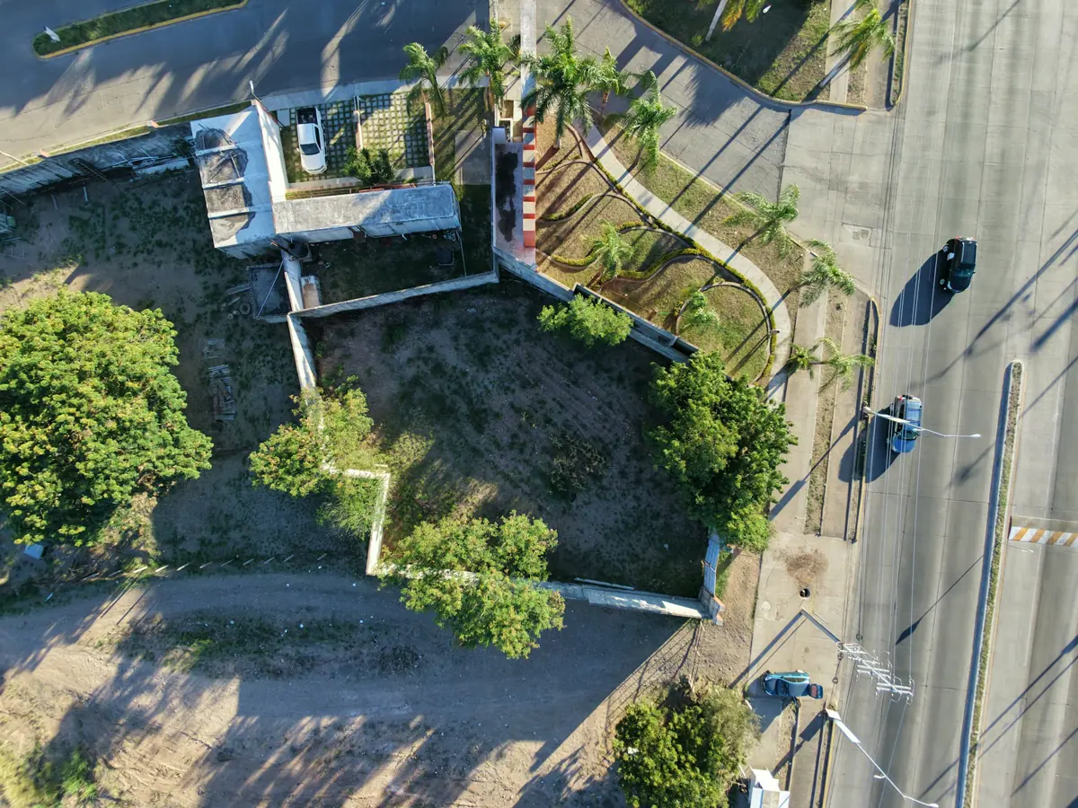 Vista aérea de un lote con árboles junto a una avenida